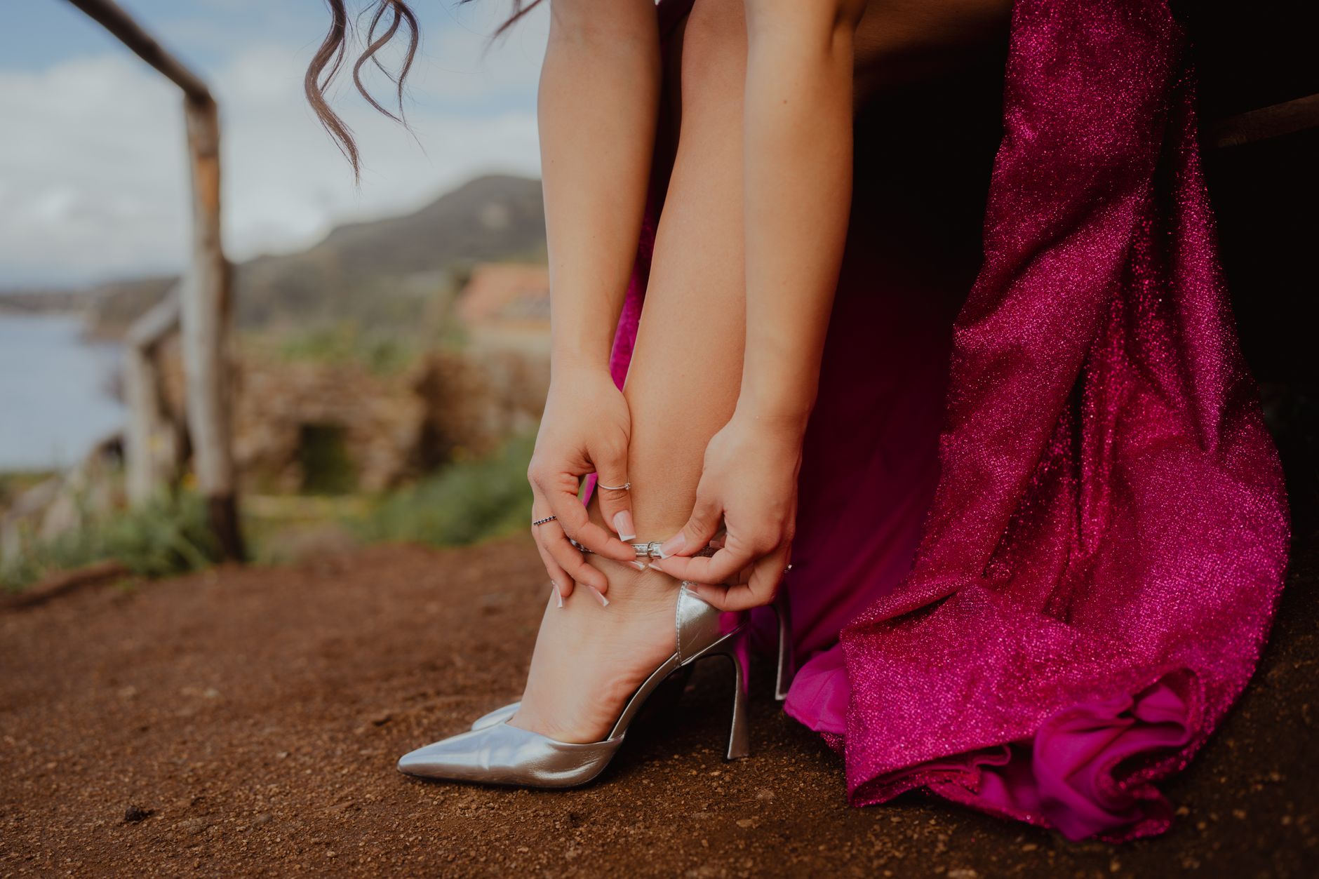 Student in a magenta formal dress getting ready for graduation